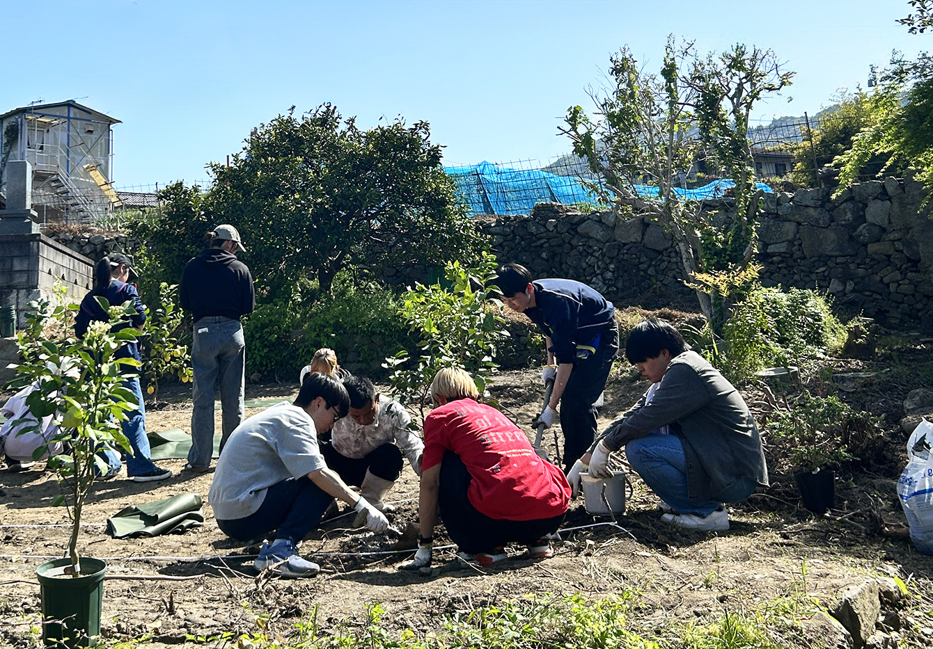 古田応援団長が学生に作業を教えている様子